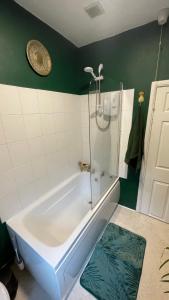 a bathroom with a bath tub with a shower at Llanfair Caereinion house Quirky with river balcony in Llanfair Caereinion