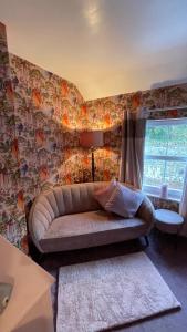 a living room with a couch and a window at Llanfair Caereinion house Quirky with river balcony in Llanfair Caereinion