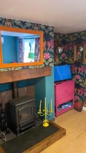 uma sala de estar com um fogão e um espelho em Llanfair Caereinion house Quirky with river balcony em Llanfair Caereinion