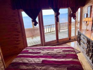 - une chambre avec un lit et une vue sur l'océan dans l'établissement Lake Michigan Cabin w/Hot Tub & Stunning Views, à Manistique