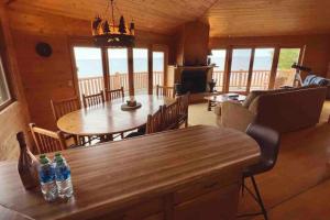 una sala da pranzo e un soggiorno in una baita di tronchi di Lake Michigan Cabin w/Hot Tub & Stunning Views a Manistique