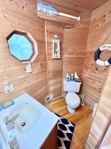 La salle de bains en bois est pourvue de toilettes et d'un lavabo. dans l'établissement Lake Michigan Cabin w/Hot Tub & Stunning Views, à Manistique