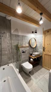 łazienka z wanną, toaletą i umywalką w obiekcie Chatka Biesczadersko w mieście Lutowiska