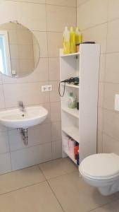 a bathroom with a sink and a toilet and a mirror at Elegant Spacious Room with Open Kitchen, Steps from Luxembourg Train Station in Luxembourg