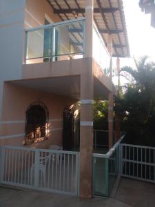 a house with a balcony with a gate at Casa de Dona Aida in Itaparica