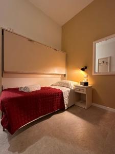 - une chambre avec un lit et une couverture rouge dans l'établissement Collegio AMDG, à Venise
