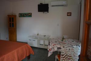 1 dormitorio con mesa y TV en la pared en Cabaña El Canal en Villa Carlos Paz