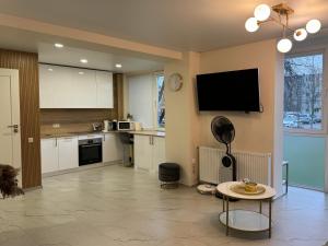 a kitchen with a tv on the wall and a table at Baltic Avenue in Klaipėda