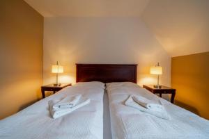 een slaapkamer met een bed met twee witte handdoeken erop bij Villa Mandát 