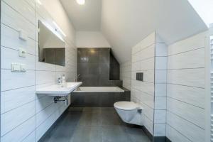 een badkamer met een toilet, een wastafel en een bad bij Villa Mandát 