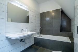 een witte badkamer met een wastafel en een bad bij Villa Mandát 