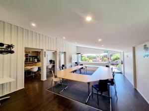a kitchen and dining room with a table and chairs at Southpacific Motel in Whangamata