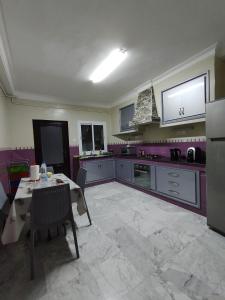 a kitchen with a table and a kitchen with purple at Appartement à louer à Tlemcen in Tlemcen