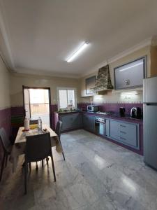 a large kitchen with a table and a refrigerator at Appartement à louer à Tlemcen in Tlemcen