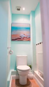 La salle de bains est pourvue de toilettes et d'une peinture murale. dans l'établissement Luxurious Contractor/Family 6 Bedroom House, à Shenley Church End