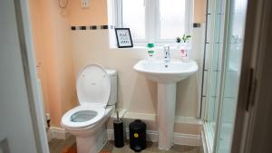 La salle de bains est pourvue de toilettes, d'un lavabo et d'une douche. dans l'établissement Luxurious Contractor/Family 6 Bedroom House, à Shenley Church End