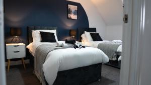 a bedroom with two beds and two tables with lamps at Luxurious Contractor/Family 6 Bedroom House in Shenley Church End