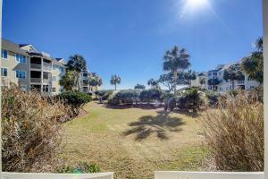 a large yard with palm trees and condos at Port O' Call G-303 in Isle of Palms
