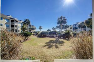 un ampio cortile con palme e condomini di Port O' Call G-303 a Isle of Palms