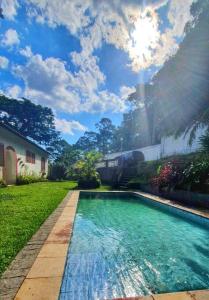 una piscina en un patio con luz solar en Sítio Pavão Azul, en Petrópolis