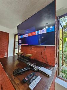 TV sobre una mesa de madera con mando a distancia en Sítio Pavão Azul, en Petrópolis