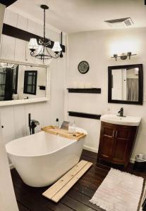 a bathroom with a large white tub and a sink at Beautiful farmhouse in Fernandina Beach in Fernandina Beach
