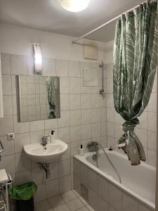 y baño con lavabo y bañera junto a un lavabo. en Schönes Appartment in Zentrumsnähe, en Graz