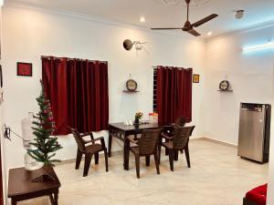 DE Villa Breeze @ Beach side في بونديتْشيري: غرفة طعام مع طاولة وشجرة عيد الميلاد