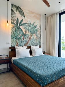 a bedroom with a bed with a mural of palm trees at PASSOT HILLS in Nosy Be