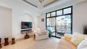 Al Tajer - Vacationer في دبي: غرفة معيشة مع كرسيين وتلفزيون