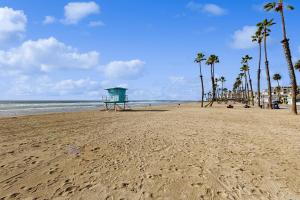 einen Strand mit Palmen und einer Rettungswache in der Unterkunft Sandcastle Cottage 22 - Historic oceanfront studio with direct beach access in Oceanside + 9 Fotos