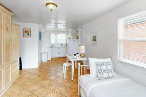 a room with a bed and a table and a kitchen at Sandcastle Cottage 22 in Oceanside