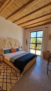 sypialnia z dużym łóżkiem i dużym oknem w obiekcie La Maison d'Hélène Essaouira w mieście Oulad el Madani