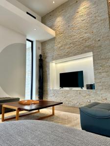 a living room with a tv on a brick wall at PASSOT HILLS in Nosy Be