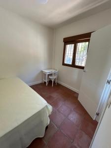 佩里那的住宿－Villarriba，一间卧室配有一张床、一张桌子和一个窗户。