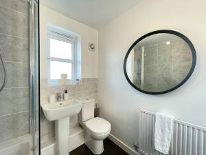 a bathroom with a toilet and a sink and a mirror at Modern Flat near Birmingham Uni with Wi-Fi & Parking in Birmingham