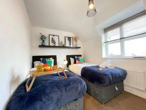 two beds with blue covers in a room at Modern Flat near Birmingham Uni with Wi-Fi & Parking in Birmingham