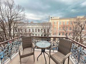 Balkon mit Tisch und 2 Stühlen in der Unterkunft Continental Hotel in Odessa
