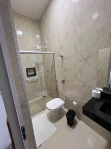 een badkamer met een douche, een toilet en een wastafel bij Hotel Xangrilá in Salinas