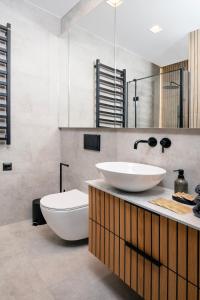 a bathroom with two sinks and a toilet in it at Łódź Prestige Suites - 64m2, Parking, Office Room - by Rentujemy in Łódź