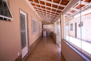 um corredor vazio de um edifício com janelas em Casa em Itaipuaçu na Praça do Ferrerinha. em Maricá