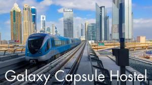 een blauwe trein op de rails in een stad bij The Galaxy Star Capsule Near Burjuman Metro Station in Dubai