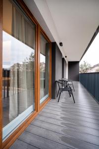 a balcony with windows and a table and chairs at Łódź Prestige Suites - 64m2, Parking, Office Room - by Rentujemy in Łódź