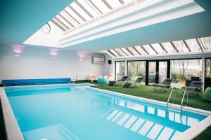 - une grande piscine dans une maison avec un salon dans l'établissement Entertainer's Estate, à Ballyeaston