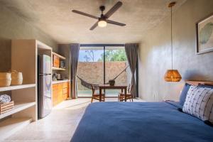 een slaapkamer met een bed, een plafondventilator en een tafel bij Original studios by Casago in Tulum +53 foto's