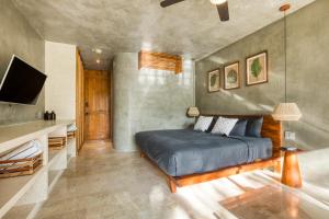 een slaapkamer met een bed en een televisie. bij Original studios by Casago in Tulum