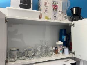 a bunch of glasses sitting on a shelf at Loft inteiro, aconchegante. in Aracaju