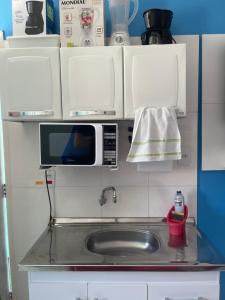 a kitchen with a sink and a microwave at Loft inteiro, aconchegante. in Aracaju