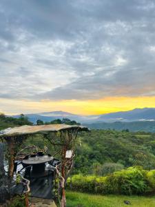 a picnic table under a gazebo with the sunset at Finca Ecoturistica Xtremly 