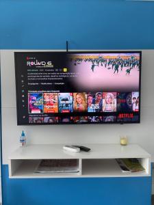 a flat screen tv sitting on top of a white shelf at Loft inteiro, aconchegante. in Aracaju